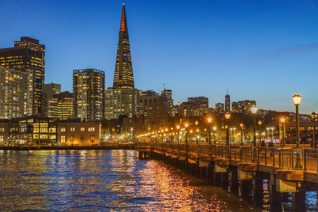 Iconic San Francisco skyline with Transamerica Pyramid and waterfront lights at twilight.